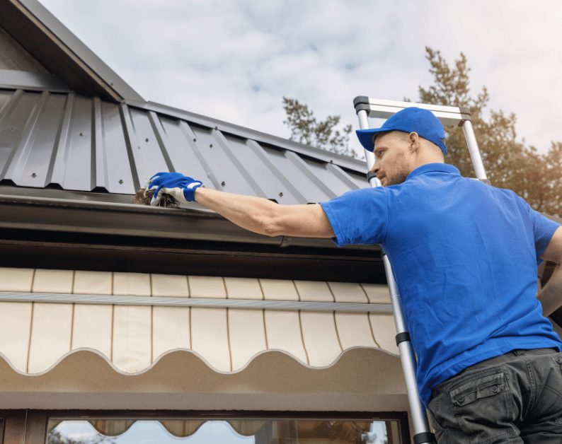 Rain gutter installed along a metal roof edge