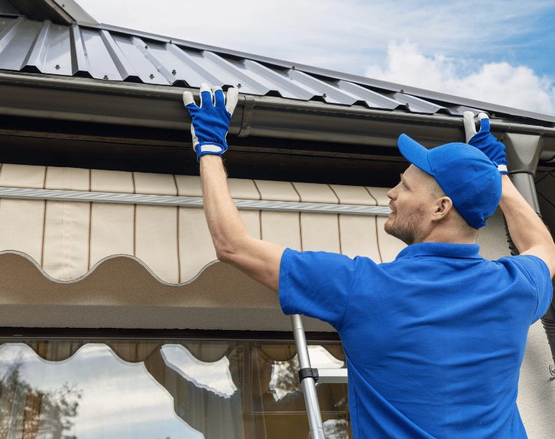Installer setting a seamless rain gutter on a home