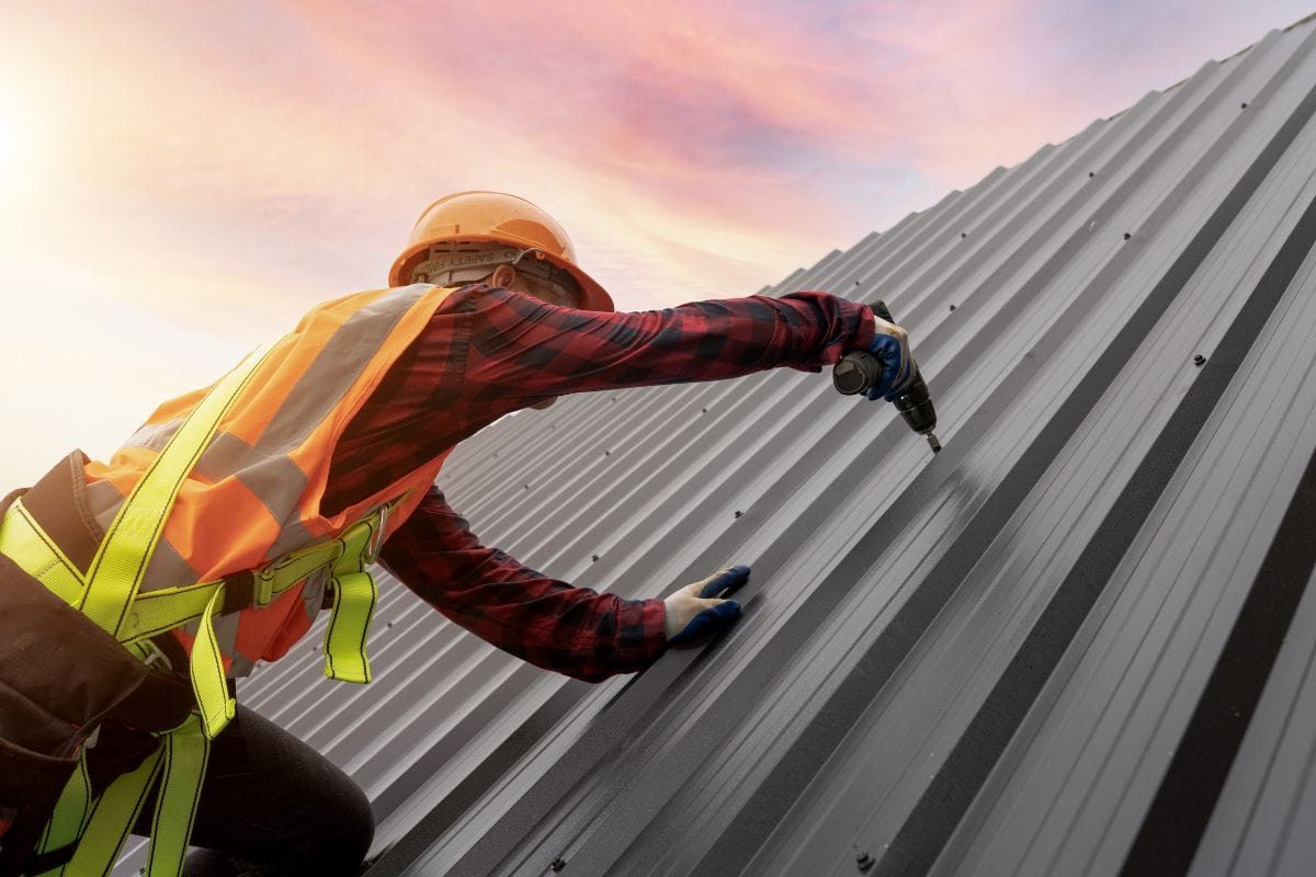 Roofer fastening metal roofing panels